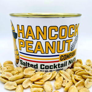 A can labeled "Amazon - Salted" sits on a white surface, with salted peanuts scattered in front. The label features bold yellow text and a peanut illustration.