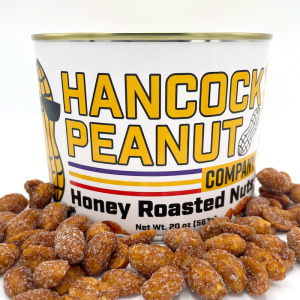 A can labeled Honey Roasted Peanuts sits surrounded by honey roasted peanuts. The label features bold yellow text and playful peanut illustrations.